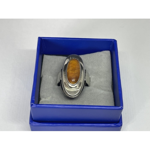 615 - A SILVER AND AMBER OVAL RING IN A PRESENTATION BOX