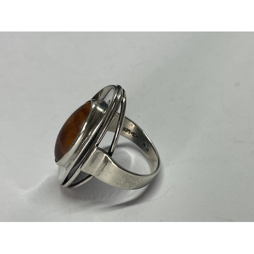 615 - A SILVER AND AMBER OVAL RING IN A PRESENTATION BOX