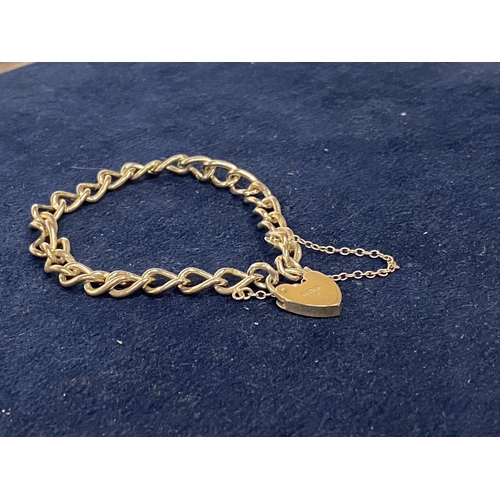 555 - A HALLMARKED SILVER BRACELET WITH A HALLMARKED HEART SHAPED LOCK ON A CURB LINK BRACELET