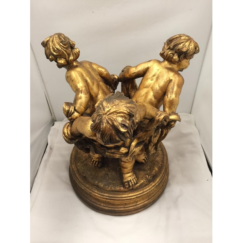 64 - A LARGE GILT COLOURED CHERUBS STAND HEIGHT 44CM, DIAMETER APPROX 34CM