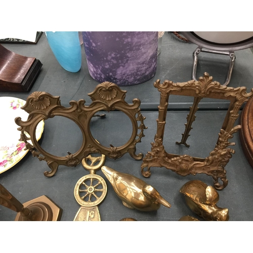 65 - A LARGE QUANTITY OF BRASSWARE TO INCLUDE CANDLESTICKS, INKWELLS, PHOTO FRAMES, ANIMALS, TRINKET BOXE... 