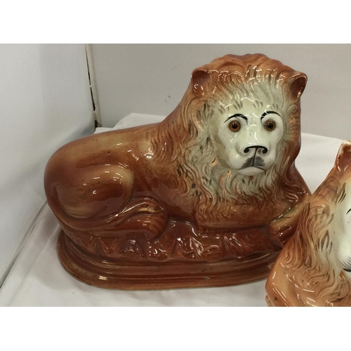 93 - A PAIR OF MID CENTURY SADLER, BURSLEM RECLINING LIONS WITH GLASS EYES - A/F CHIPS TO BASE