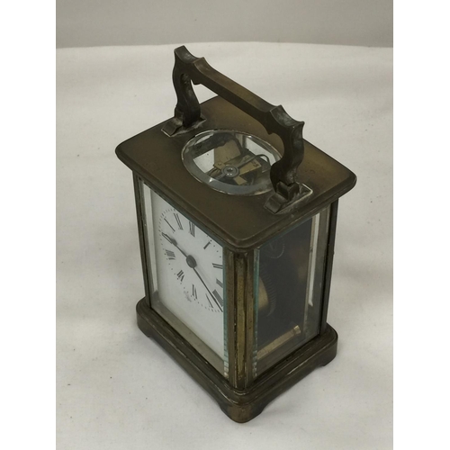 96 - A BRASS AND GLASS CARRIAGE CLOCK, THE GLASS BEING BEVELLED SHOWING ALL FOUR SIDES OF THE CLOCK'S INN... 