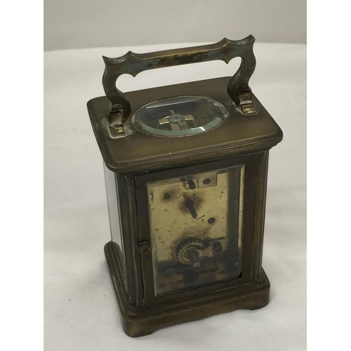 96 - A BRASS AND GLASS CARRIAGE CLOCK, THE GLASS BEING BEVELLED SHOWING ALL FOUR SIDES OF THE CLOCK'S INN... 