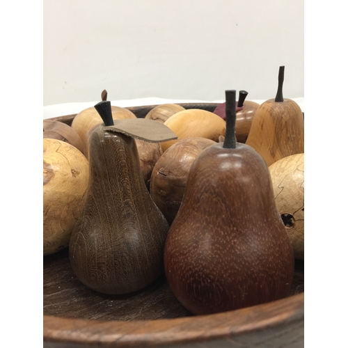 121 - A LARGE TREEN BOWL CONTAINING A QUANTITY OF CARVED FRUITS