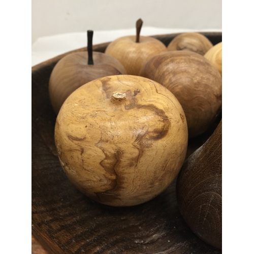 121 - A LARGE TREEN BOWL CONTAINING A QUANTITY OF CARVED FRUITS