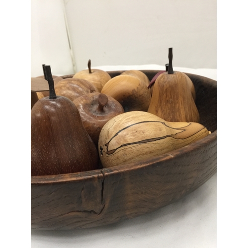 121 - A LARGE TREEN BOWL CONTAINING A QUANTITY OF CARVED FRUITS