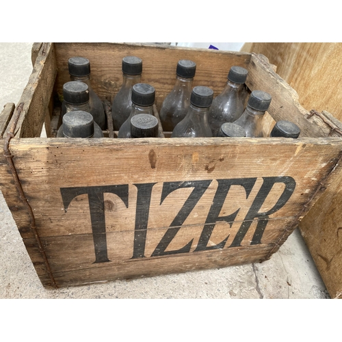 1211 - A VINTAGE WOODEN MONOGRAMED TIZER CRATE CONTAINING 12 VINTAGE GLASS TIZER BOTTLES