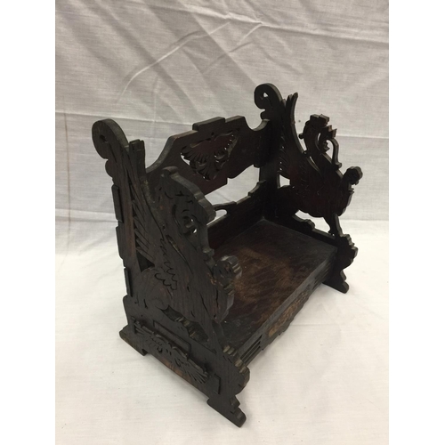 17 - A VINTAGE WOODEN BOOK CASE WITH DRAGON DESIGN AND A FURTHER OAK EXTENDING BOOK TROUGH