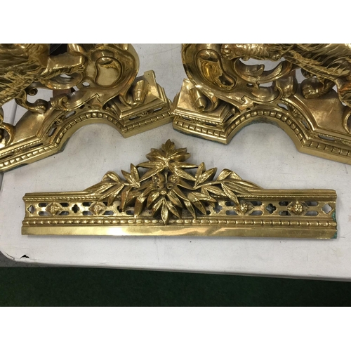 25 - A PAIR OF HEAVY BRASS FIRE DOGS WITH TIGER DECORATION AND A MATCHING BRASS FIRE FENDER