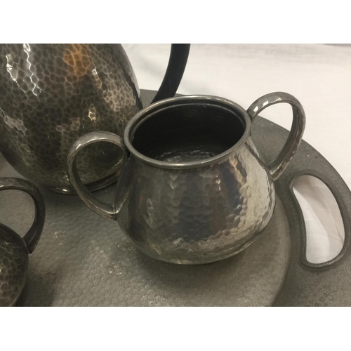 6 - A HAND HAMMERED SIX PIECE TUDRIC PEWTER SET