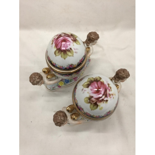 151 - A PAIR OF RENAISSANCE STYLE ORNATE TRINKET BOXES WITH CHERUBS PLUS A FLORAL CERAMIC MANTLE CLOCK