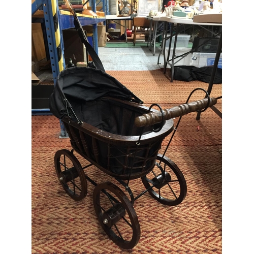 234 - A VINTAGE STYLE  WOODEN DOLL'S PRAM WITH METAL SUSPENSION, A HOOD AND BLACK FITTED INTERIOR