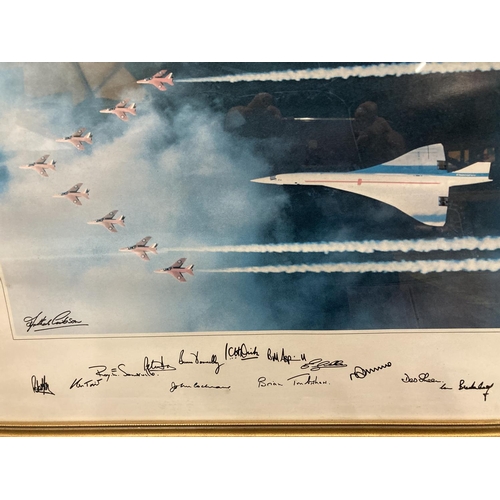 358 - A FRAMED PRINT OF CONCORDE FLYING WITH THE RED ARROWS WITH SIGNATURES TO THE BOTTOM 54CM X 43.5CM