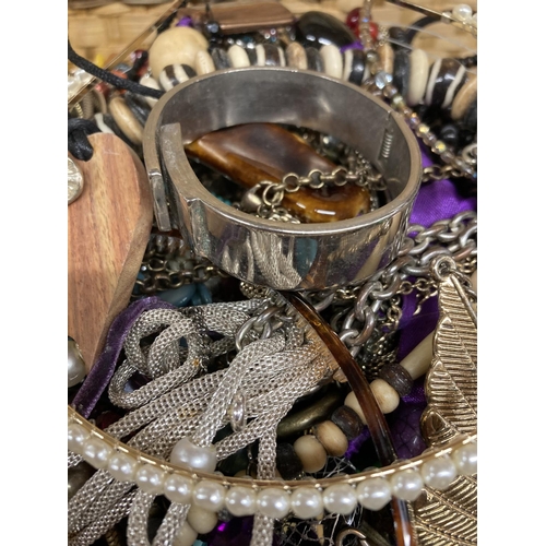 422 - A WICKER PICNIC BASKET CONTAINING A QUANTITY OF COSTUME JEWELLERY TO INCLUDE BANGLES, NECKLACES, BRA... 