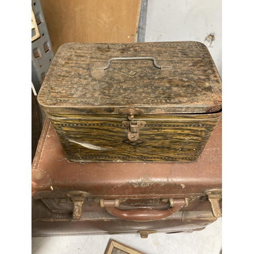 910 - A LARGE AND SMALL VINTAGE LEATHER SUITCASE PLUS TWO VINTAGE TINS