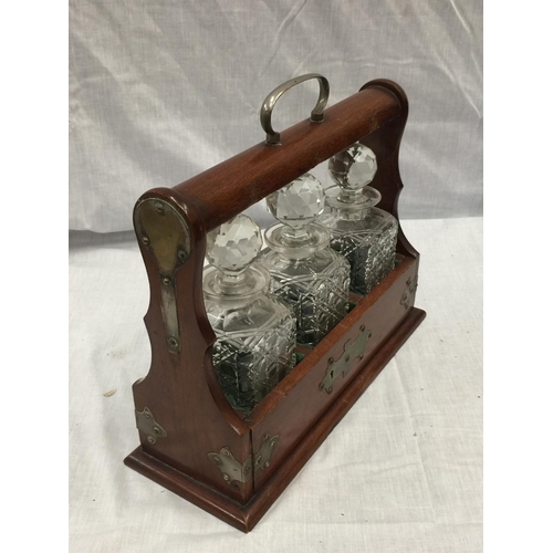 13 - A MAHOGANY TANTALUS WITH BRASS DETAILING AND THREE CUT GLASS DECANTERS. COMES WITH KEY BUT WILL NOT ... 