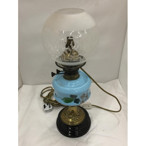 50 - A CONVERTED VINTAGE BRASS OIL LAMP ON BRASS STAND AND SOLID HEAVY BASE WITH PAINTED CERAMIC DECORATI... 