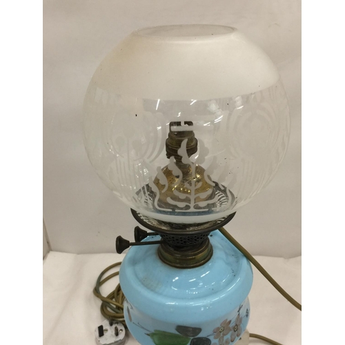 50 - A CONVERTED VINTAGE BRASS OIL LAMP ON BRASS STAND AND SOLID HEAVY BASE WITH PAINTED CERAMIC DECORATI... 