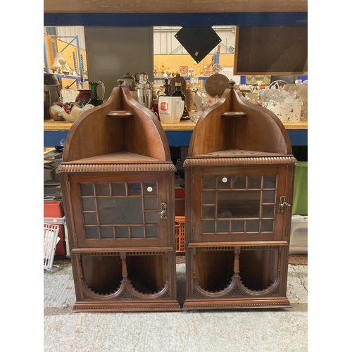 279A - A PAIR OF EDWARDIAN MAHOGANY ASTRAGAL GLAZED CORNER CABINETS WITH CARVED ARCHED TOPS AND LOCKING KEY... 