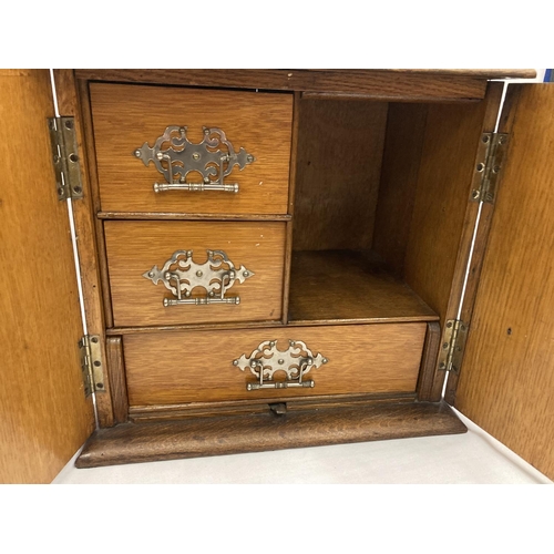 280A - AN OAK SMOKERS CABINET WITH THREE ENCLOSED DRAWERS H: 30CM, W: 32CM