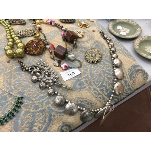 168 - A QUANTITY OF COSTUME JEWELLERY ON A CUSHION TO INCLUDE NECKLACES AND VINTAGE BROOCHES SET WITH DIAM... 