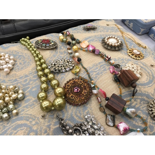 168 - A QUANTITY OF COSTUME JEWELLERY ON A CUSHION TO INCLUDE NECKLACES AND VINTAGE BROOCHES SET WITH DIAM... 