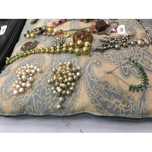 168 - A QUANTITY OF COSTUME JEWELLERY ON A CUSHION TO INCLUDE NECKLACES AND VINTAGE BROOCHES SET WITH DIAM... 