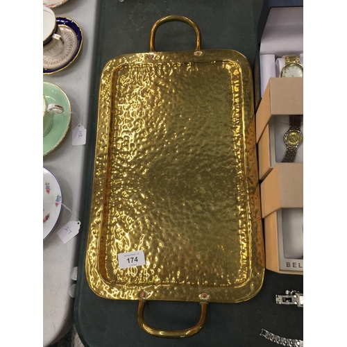 174 - A BEATEN BRASS TWO HANDLED TRAY 39CM X 25CM