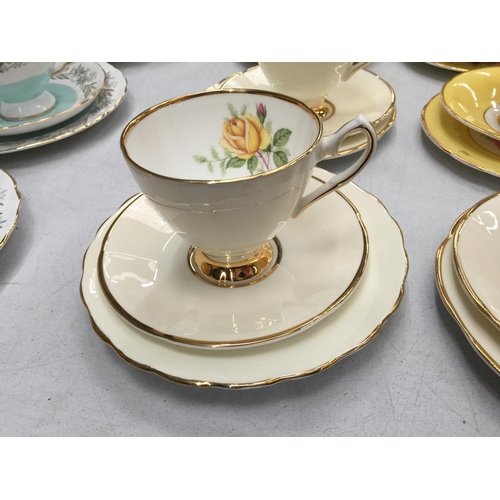 192 - SIX BONE CHINA TRIOS WITH ROSE DECORATION AND GILDING TO THE RIMS AND HANDLES