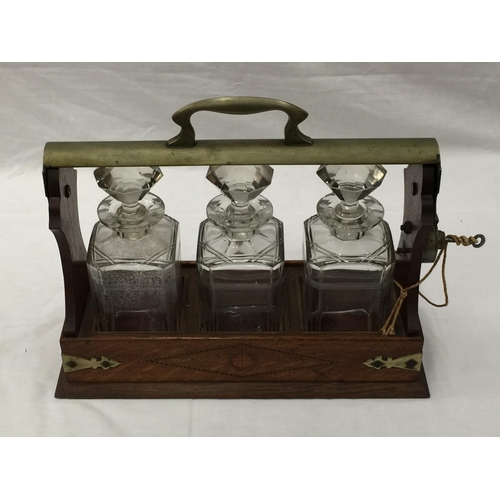 14 - A VINTAGE MAHOGANY AND BRASS TANTALUS WITH THREE MATCHING DECANTERS AND KEY