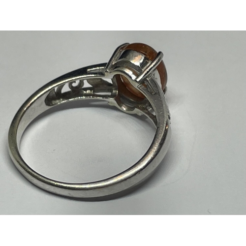 503 - A 9 CARAT WHITE GOLD RING WITH AN ORANGE CABOCHON STONE SIZE N/O