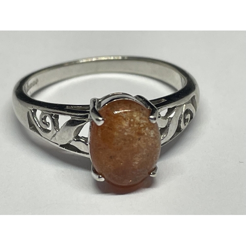 503 - A 9 CARAT WHITE GOLD RING WITH AN ORANGE CABOCHON STONE SIZE N/O