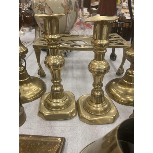 81 - A QUANTITY OF BRASSWARE TO INCLOUDE CANDLESTICKS, TRIVET, MINIATURE MINERS LAMPS, PLATES, ETC