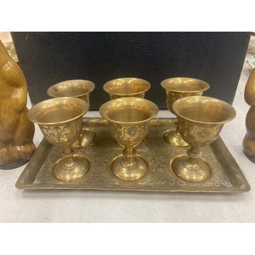 84 - A VINTAGE BLUE CASE TO INCLUDE A BRASS TRAY CONTAINING SIX SMALL GOBLETS, HORSE PLAQUE, CARVED WOODE... 