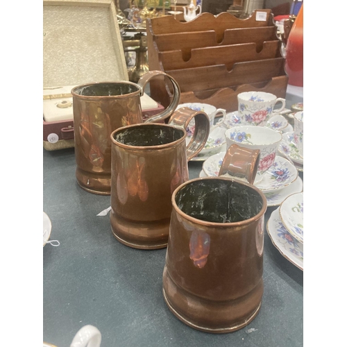 112 - THREE GRADUATED COPPER TANKARDS