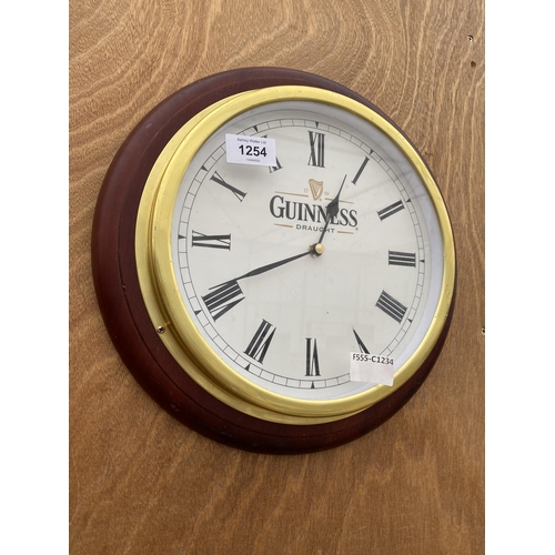 1254 - A WOODEN FRAMED BRASS WALL CLOCK BEARING THE NAME 'GUINNESS'