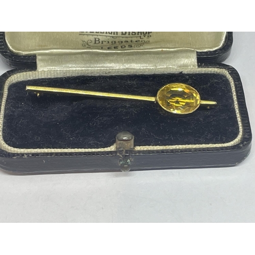 632 - A YELLOW METAL AND CITRINE PIN BROOCH IN A PRESENTATION BOX