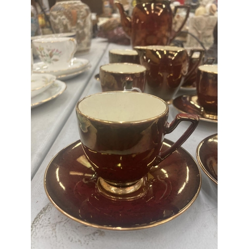 77 - A CARLTON WARE COFFEE SET IN A CRISOM LUSTRE WARE TO INCLUDE COFFEE SET, SUGAR BOWL, CREAM JUG, CUPS... 