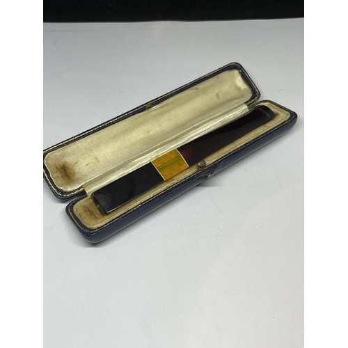 632 - AN AMBER CHEROOT HOLDER IN A CASE