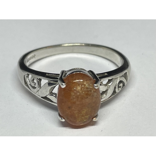 646 - A 9 CARAT WHITE GOLD RING WITH AN ORANGE CABOCHON STONE SIZE N/O