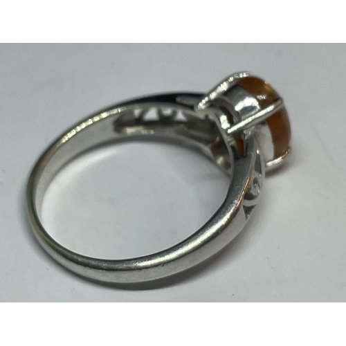 646 - A 9 CARAT WHITE GOLD RING WITH AN ORANGE CABOCHON STONE SIZE N/O