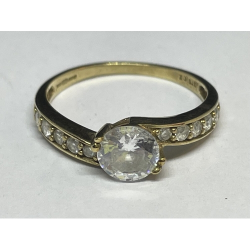 647 - A 9 CARAT GOLD RING WITH A CENTRE CUBIC ZIRCONIA AND TEN ON THE SHOUDLERS SIZE N/O