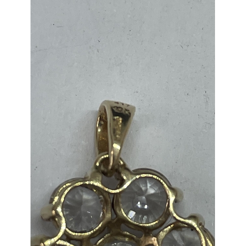 690 - A 10 CARAT GOLD PENDANT WITH A CLEAR STONE FLOWER DESIGN