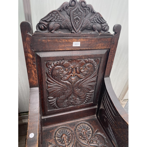 2203 - AN 18TH CENETURY OAK WAINSCOT CHAIR WITH CARVED BACK PANEL AND SEAT WITH MYTHICAL DRAGON LIKE ARM TE... 