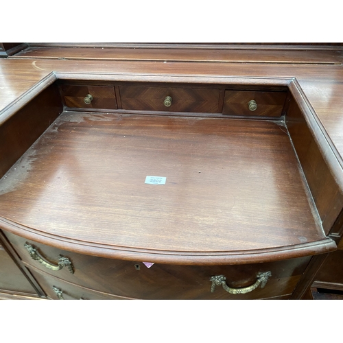 2502 - AN EDWARDIAN MAHOGANY BOW FRONTED DRESSING TABLE ENCLOSING FOUR SHORT, TWO LONG AND THREE JEWELLED D... 