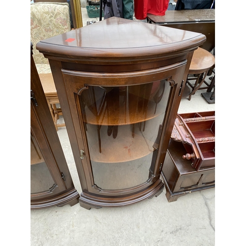 2519 - A PAIR OF MODERN MAHOGANY BOW FRONTED CORNER CABINETS ON BRACKET FEET, 24