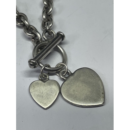 705 - A SILVER T BAR NECKLACE WITH HEART PENDANTS