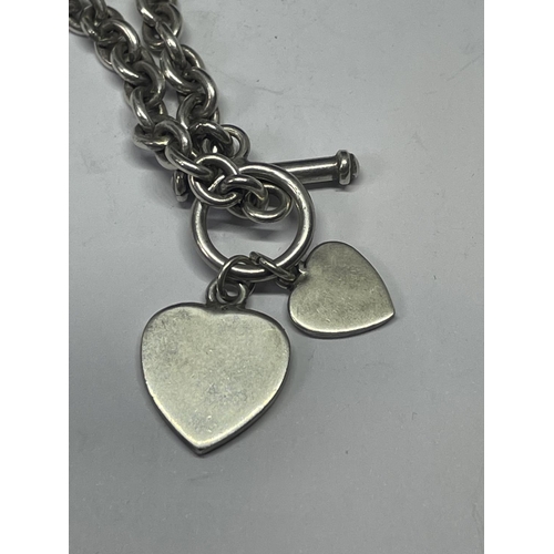 705 - A SILVER T BAR NECKLACE WITH HEART PENDANTS