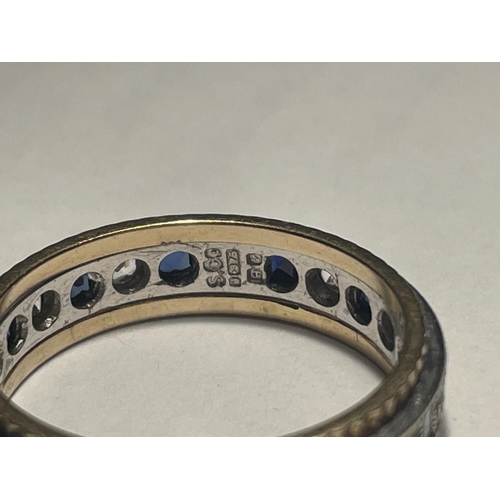 609 - A 9 CARAT GOLD RING WITH A BAND OF SAPPHIRES AND CUBIC ZIRCONIA STONES